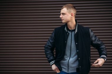 Koyu çizgili duvarlarının poz ve fotoğrafçı gülümseyen bir arka plan siyah ceketli genç bir adam