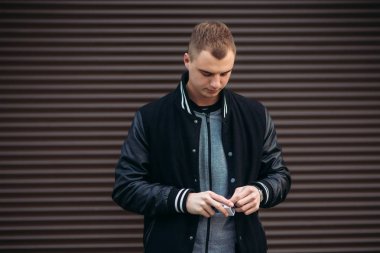 Koyu çizgili duvarlarının poz ve fotoğrafçı gülümseyen bir arka plan siyah ceketli genç bir adam