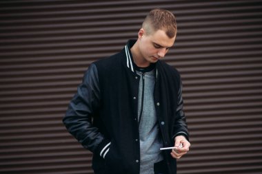 Koyu çizgili duvarlarının poz ve fotoğrafçı gülümseyen bir arka plan siyah ceketli genç bir adam