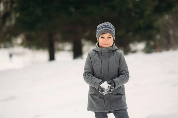 Egy kis fiú séta a parkban, a téli időjárás, játék hógolyókat, és örvendezett. Karácsonyi hangulat vár — Stock Fotó