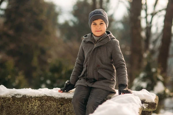 Egy kis fiú séta a parkban, a téli időjárás, játék hógolyókat, és örvendezett. Karácsonyi hangulat vár — Stock Fotó
