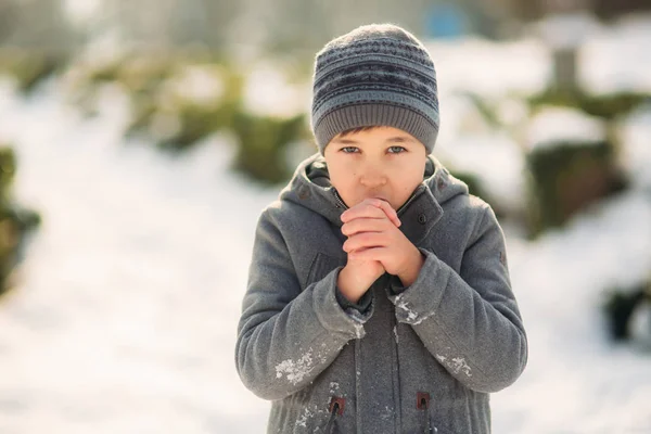 Un ragazzo riscalda le mani dal freddo in inverno — Foto Stock