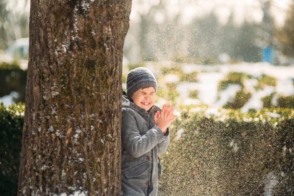 A boy warms his hands from the cold in winter