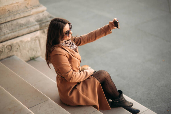 Beautiful girl in sunglasses make photo on smartphone. selfie