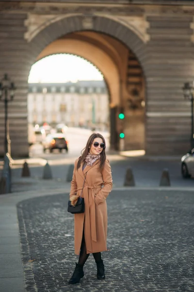 Стильна дівчина в пальто позує для фотографа — стокове фото