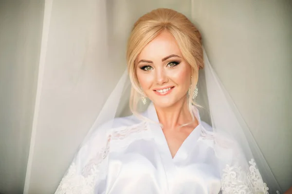 Retrato de una novia en un vestido de novia. La novia se viste en el hotel — Foto de Stock