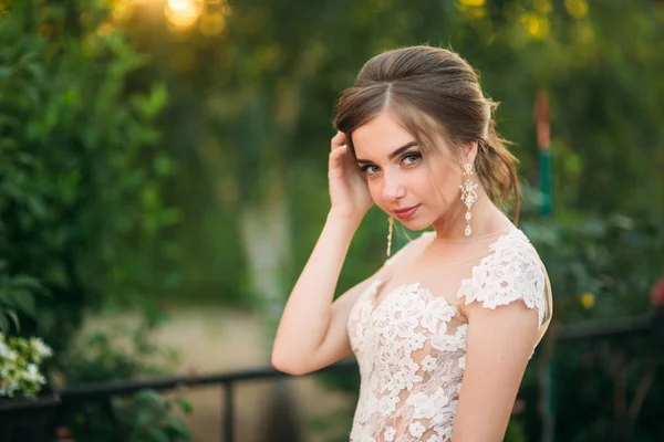 Chica joven en vestido de novia en el parque posando para el fotógrafo. Tiempo soleado, verano — Foto de Stock