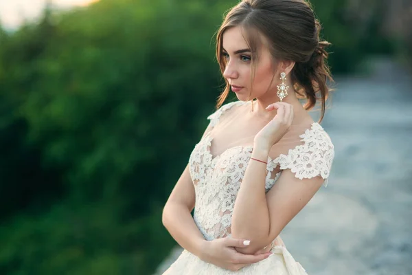 Young girl in wedding dress on city background at sunset. Summer — Stock Photo, Image