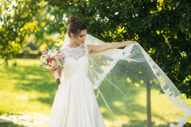 Güzel gelin gelinlik duvak parkta oynamak