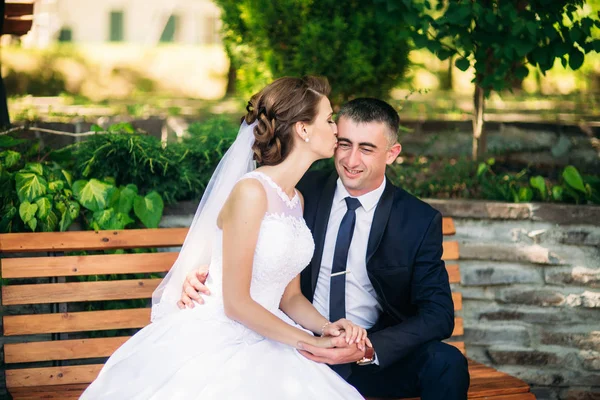 Novia y novio sentados en el banco — Foto de Stock