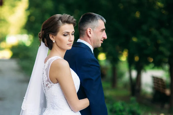 Casal jovem, noiva e noivo andando e desfrutando de seu dia de casamento. Luz do sol. Verão — Fotografia de Stock