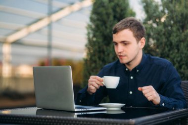 Kahve molası bir dizüstü bilgisayar üzerinde çalışan genç Yöneticisi. Öğle yemeği molası.