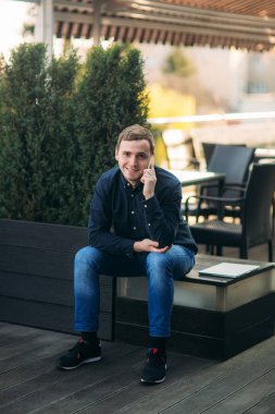 Genç bir adamın cep telefonundan konuşuyor. İş