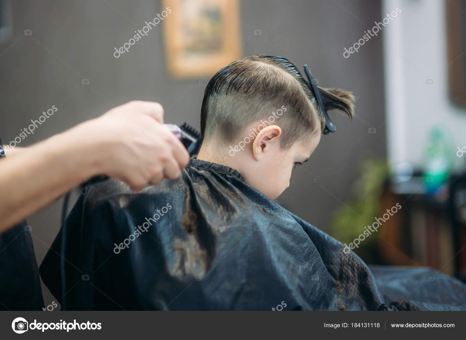 Little Boy On A Haircut In The Barber Sits On A Chair Stock
