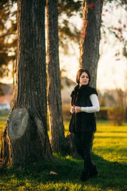 Genç bir anne parkta altın sonbaharda yürür.