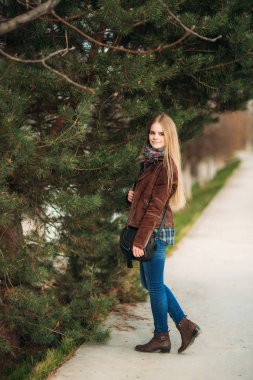 Sarışın kız parkta yürüyüş. Fotoğrafçı için poz.