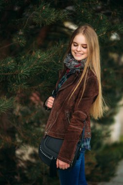 Güzel bir kız set yürüyor. Sarı saçlı ve kahverengi ceket. Bahar