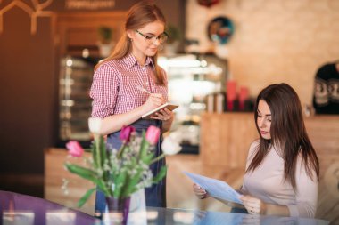 Misafirperver garsonla notepapers ve kalem sipariş almaya hazır