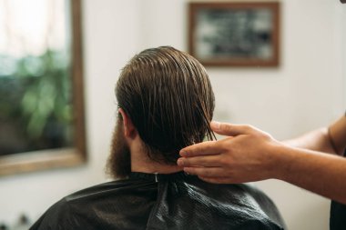 Erkek müşteri kuaföre tıraş oluyor.