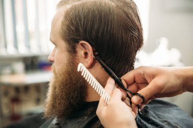 Erkek müşteri kuaföre tıraş oluyor.