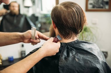 Sakallı adam bir saç kesimi saç kesme makineleri ile sahip