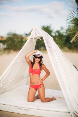 Seksi kız plaja güneşli hava yakın yüzme havuzunda yüzüyor. Yaz 