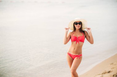 Seksi kız sahilde pembe bir mayo içinde. Yaz. güneşli havalarda