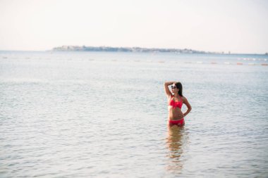 Güzel kız pembe mayo, denizin içinde. Güneşli havalarda. Yaz