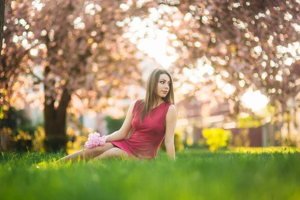 Belle fille posant au photographe sur fond de fleurs d'arbres roses. Le printemps. Sakura — Photo