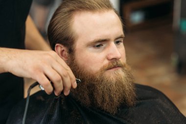 Sakallı adam bir saç kesimi saç kesme makineleri ile sahip