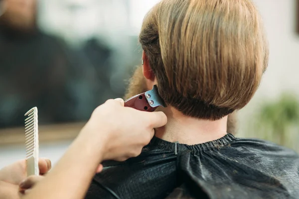 Bir saç kesimi saç kesme makineleri ile sahip sakallı adam. Closeup görünümü ile sığ derinlik-in tarla — Stok fotoğraf