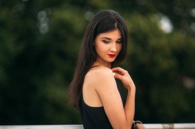 Esmer kız makyaj ile yeşil arka plan önünde duruyor