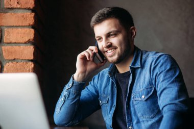 Telefonunuzun ve içinde bir restoran denim gömlekli sakallı adam