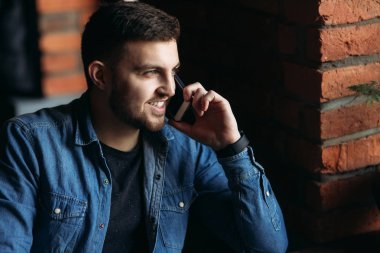 Telefonunuzun ve içinde bir restoran denim gömlekli sakallı adam