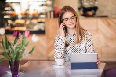 güzel sarışın Bayan kullanın farklı gadget'lar ve içme kahve kafede