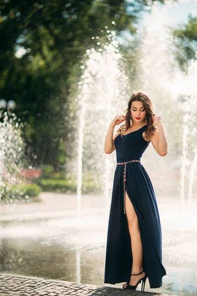 Une fille se promène dans la ville, près d'une grande fontaine . — Photo