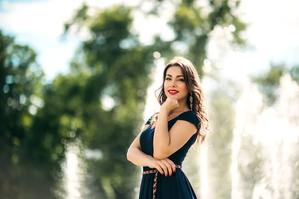 Una chica está caminando por la ciudad, cerca de una gran fuente . —  Fotos de Stock