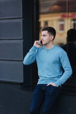 Yakışıklı adam sokakta telefonu kullanıyor