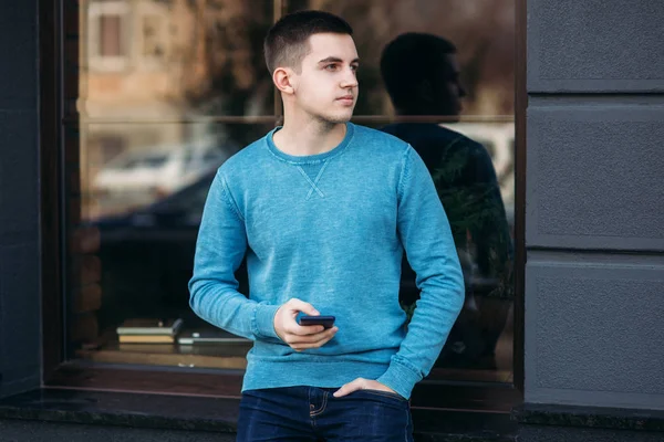 Un hombre guapo está usando el teléfono en la calle. — Foto de Stock