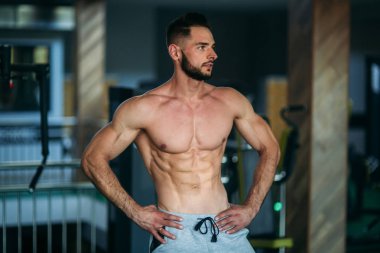 Genç bir atlet spor salonunda eğitiyor. Kas gösterir