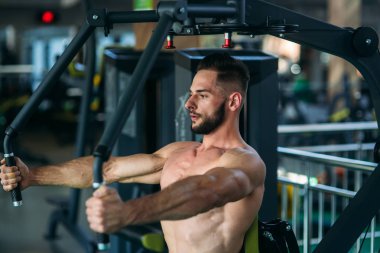 Genç bir atlet spor salonunda eğitiyor. Vücut geliştirmeci göğüs muscules trenler