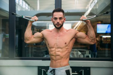 Genç bir atlet spor salonunda eğitiyor. Trians pazı muscules