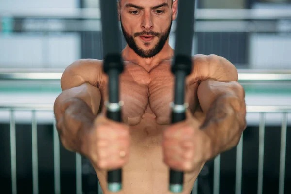 Genç bir atlet spor salonunda eğitiyor. Vücut geliştirmeci göğüs muscules trenler — Stok fotoğraf