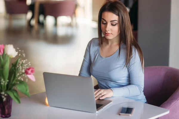 Mulher morena trabalhando em seu laptop em um restaurante — Fotografia de Stock