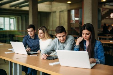Üniversite öğrencilerinin okul Kütüphanesi, bir kız ve bir erkek eğitim grup olup bir dizüstü bilgisayar kullanarak Internet'e bağlanma