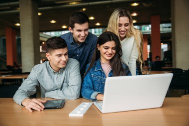 Üniversite öğrencilerinin okul Kütüphanesi, bir kız ve bir erkek eğitim grup olup bir dizüstü bilgisayar kullanarak Internet'e bağlanma