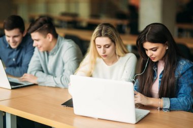 Üniversite öğrencilerinin okul Kütüphanesi, bir kız ve bir erkek eğitim grup olup bir dizüstü bilgisayar kullanarak Internet'e bağlanma