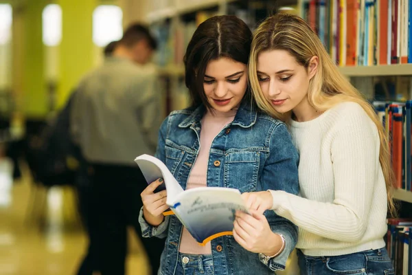 Grupo de estudiantes quieren encontrar un poco de literatura útil para la preparación para el examen universitario — Foto de Stock