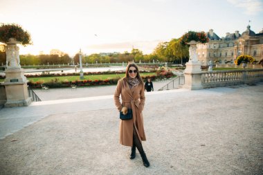 Şık kız fotoğrafçısına poz paltolu. Park