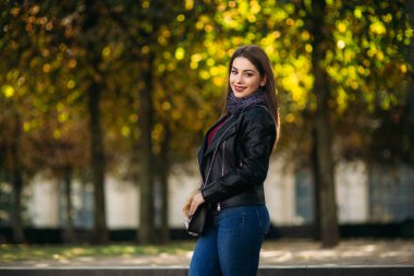 Siyah deri ceketli, siyah çantalı ve kahverengi kürklü şık bir bayan.